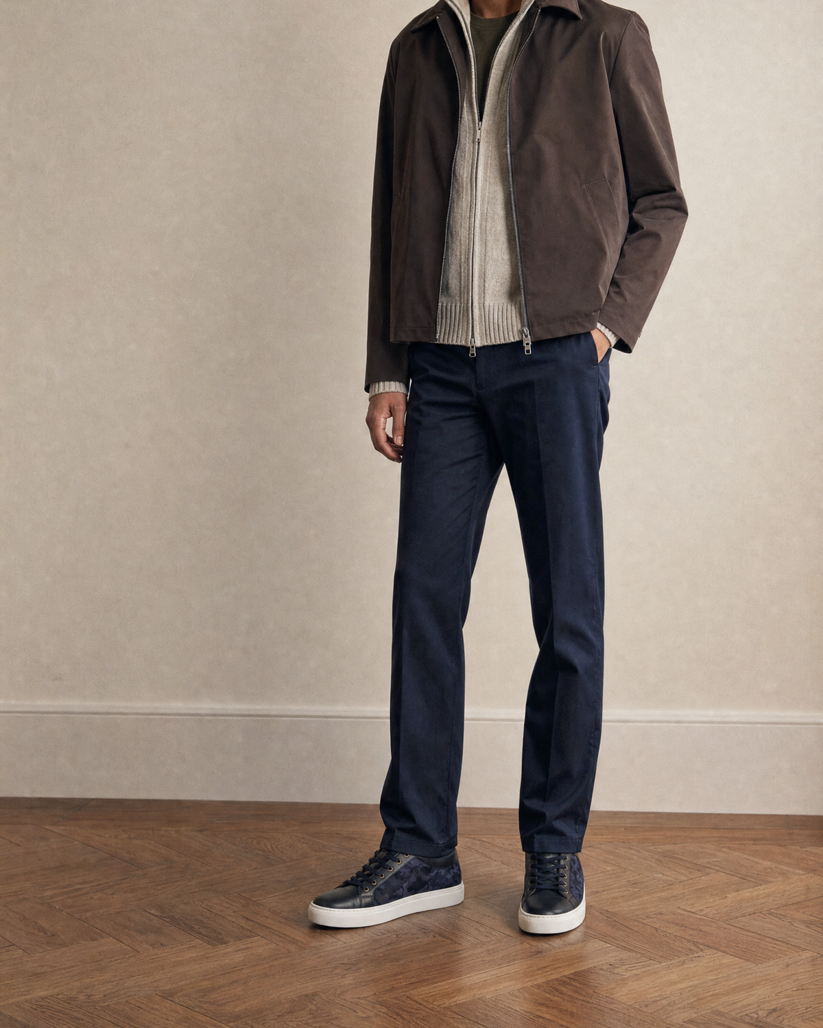 Bivando Midnight Camo Sneakers worn with navy trousers, a brown suede jacket and a cream zip-up knit